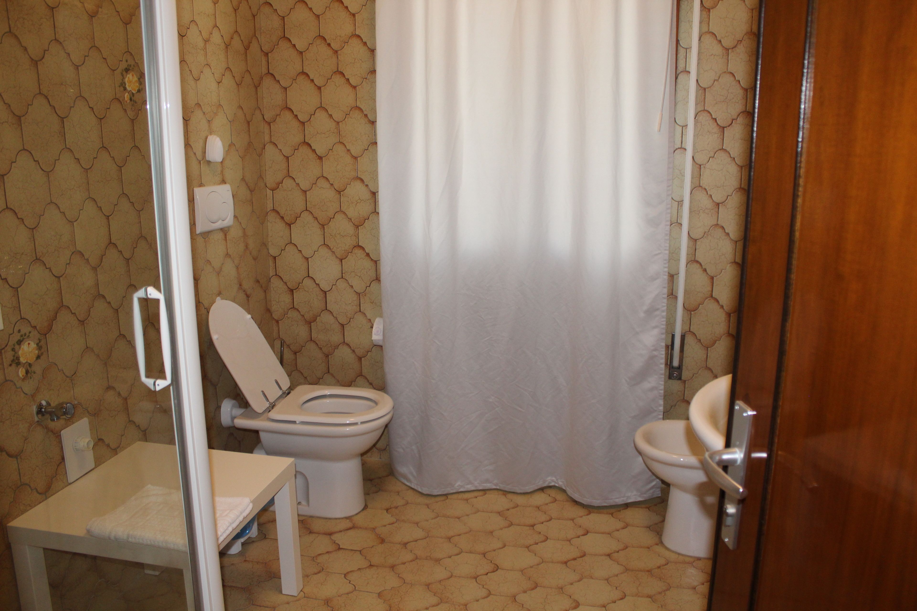 Ein Badezimmer mit Toilette, Waschbecken und Duschbereich.