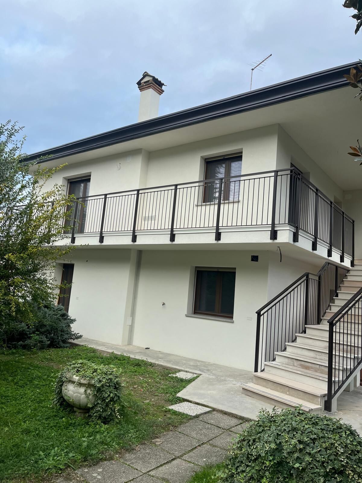 Un bâtiment à deux étages doté d’un balcon, d’une cheminée et d’un escalier menant à l’étage supérieur.