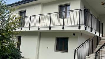 Un bâtiment à deux étages doté d’un balcon, d’une cheminée et d’un escalier menant à l’étage supérieur.