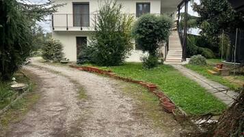 Una casa de dos pisos con un camino de grava que conduce a la puerta principal.
