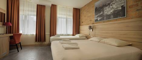 Habitación de hotel con dos camas, un escritorio y una silla.