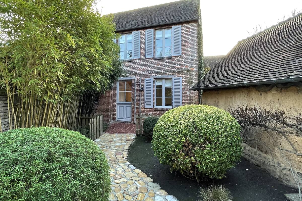 A two-story brick house with a stone pathway leading to the entrance.