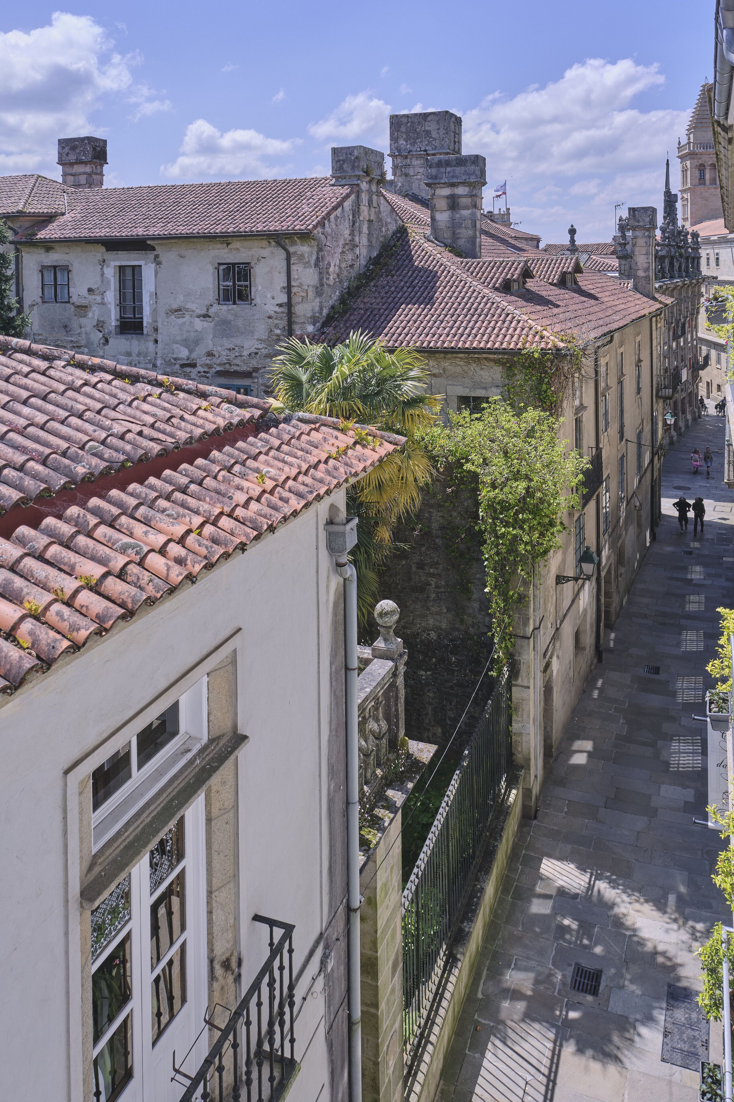 Une rue étroite bordée de bâtiments historiques, un escalier bien visible et un ciel dégagé.