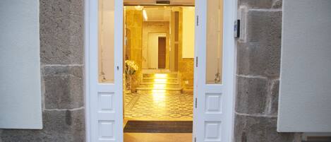 A stone building with a hallway leading to a door.