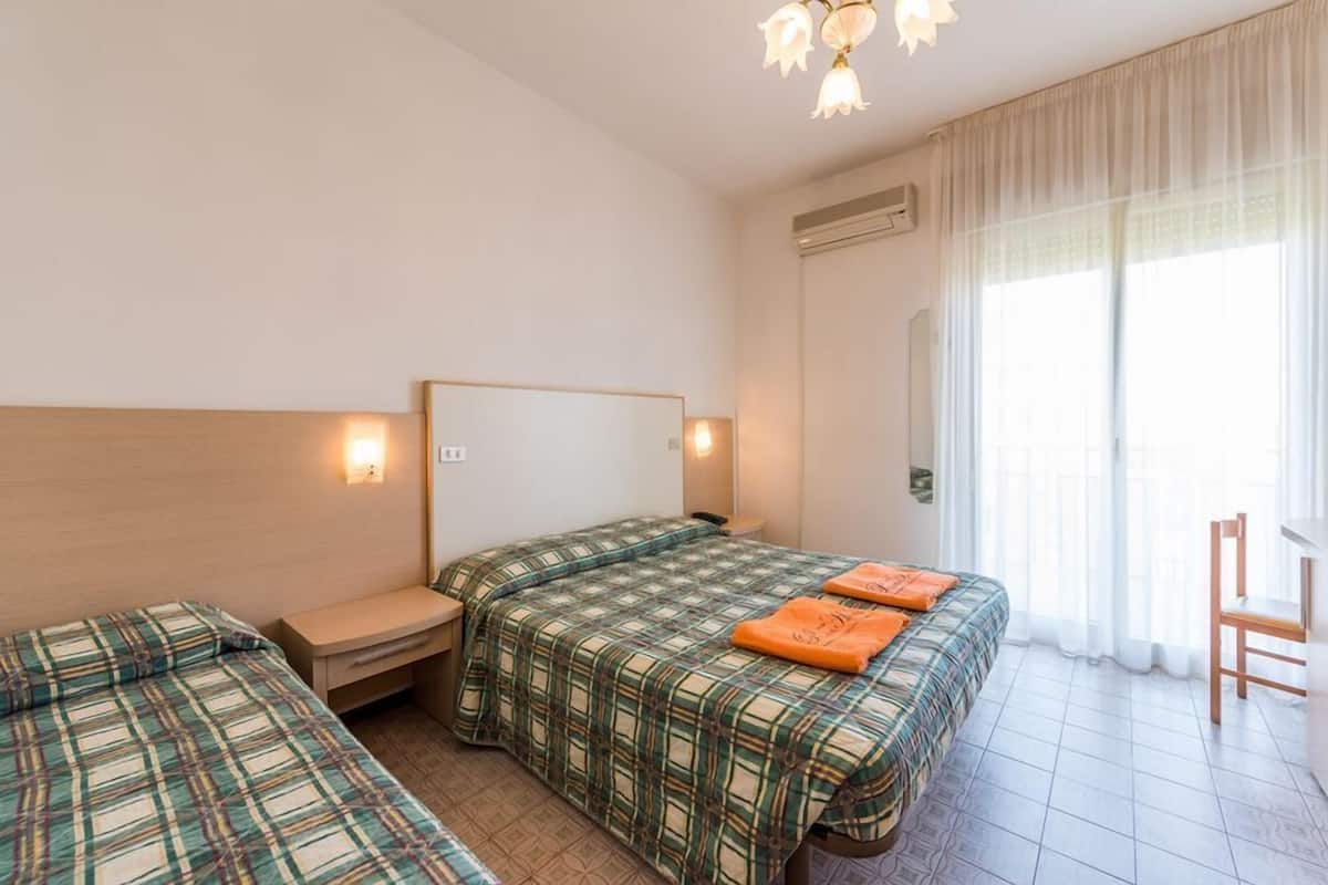 Ein Hotelzimmer mit zwei Betten, einem Schreibtisch und einem Stuhl.