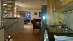 A kitchen with a sink, a dining area with a table and chairs, and a view of the outside through a window. - MetroStays - Stephen's Green 7-3 (Dublin)