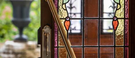 A close-up of a stained glass door with a brass handle and a keyhole.