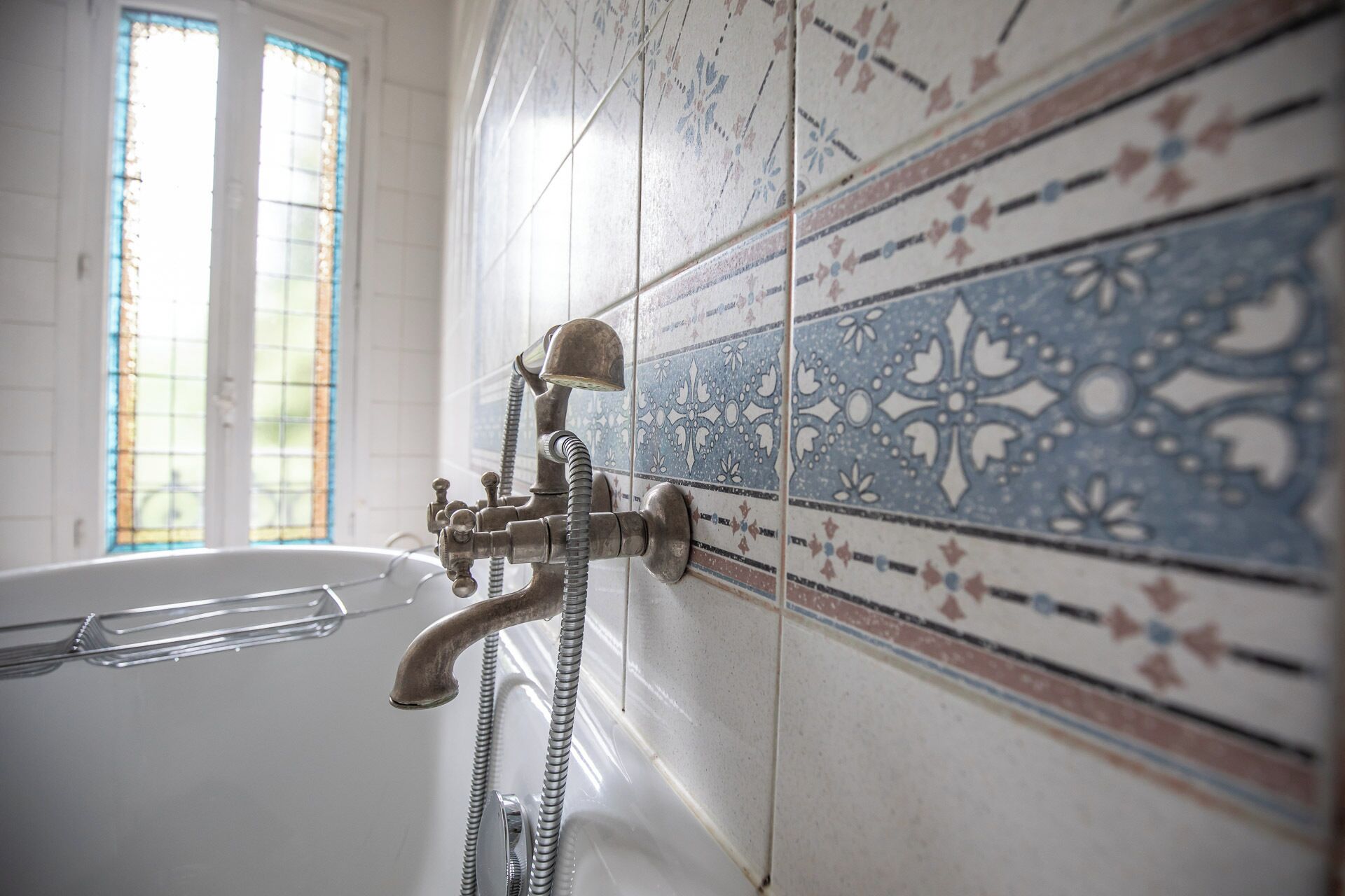 A bathroom with a bathtub, a shower, and a window.