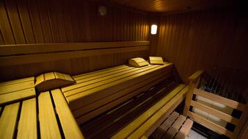 Una sauna con bancos de madera y un ventanal pequeño.