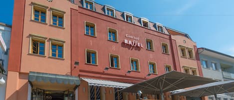 A building with a red facade, numbered windows, and a sign reading "Gasthof RAFFEL".