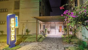 A hotel entrance with a sign reading "PECEM hotel" and a covered walkway leading to the entrance.