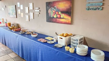 Een buffet met verschillende gerechten en een schilderij aan de muur.