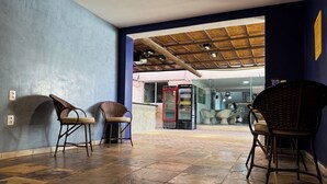 A hallway with stone flooring, wicker chairs, and a Heineken refrigerator.