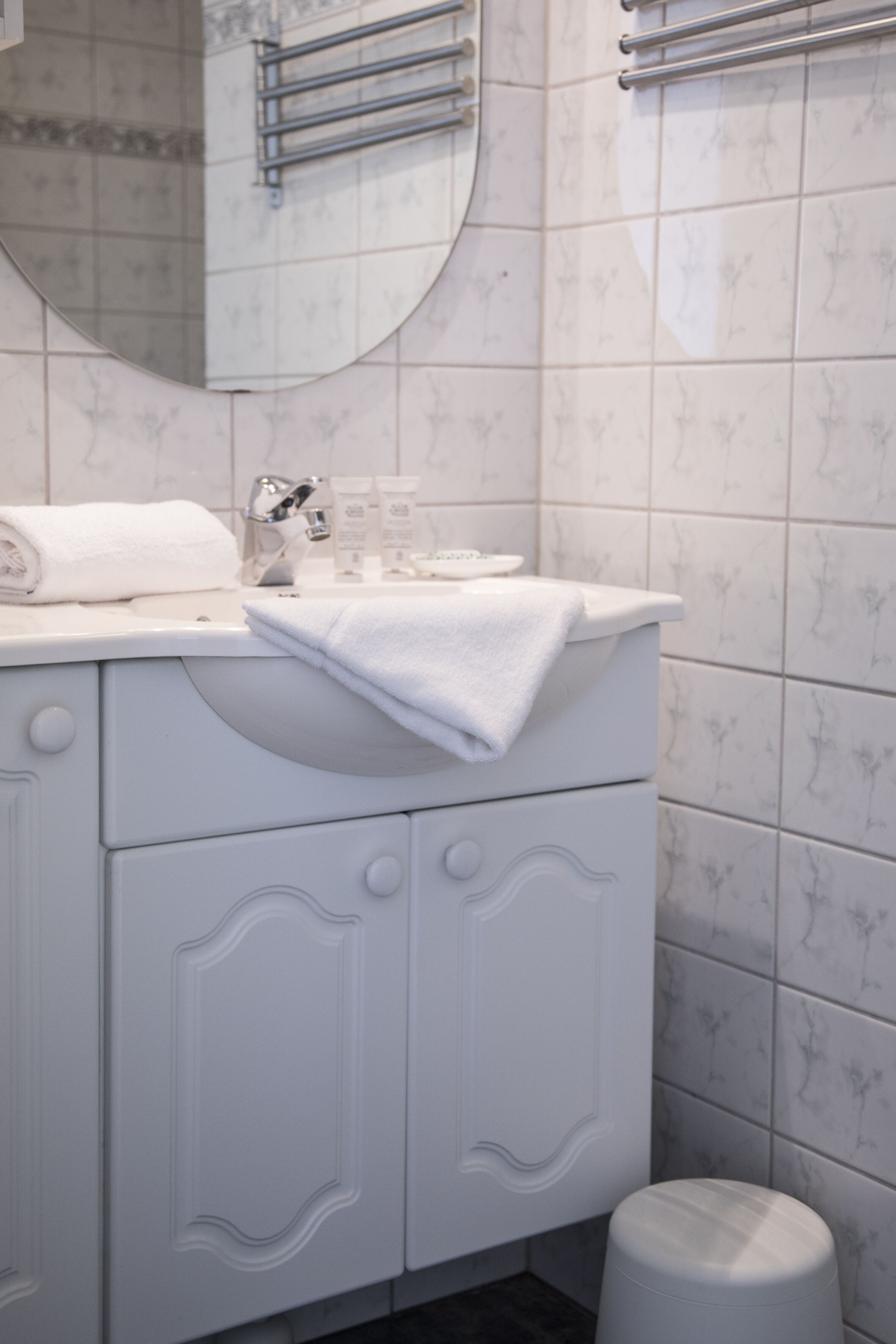Een badkamer met witte meubels, een wastafel en een toilet.