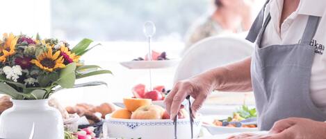 A kitchen counter with various food items and a person preparing food.