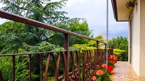 A balcony with a checkered floor, a metal railing, and potted flowers. - Airport Venice Diego 2 (Mestre)