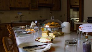 A kitchen with wooden cabinets, a dining table set with plates, glasses, and food items. - Airport Venice Diego 2 (Mestre)