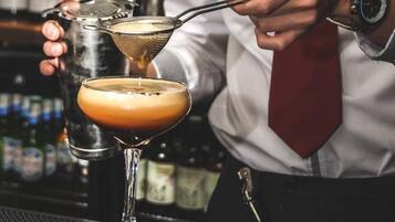 Un barista prepara un cocktail con un colino.