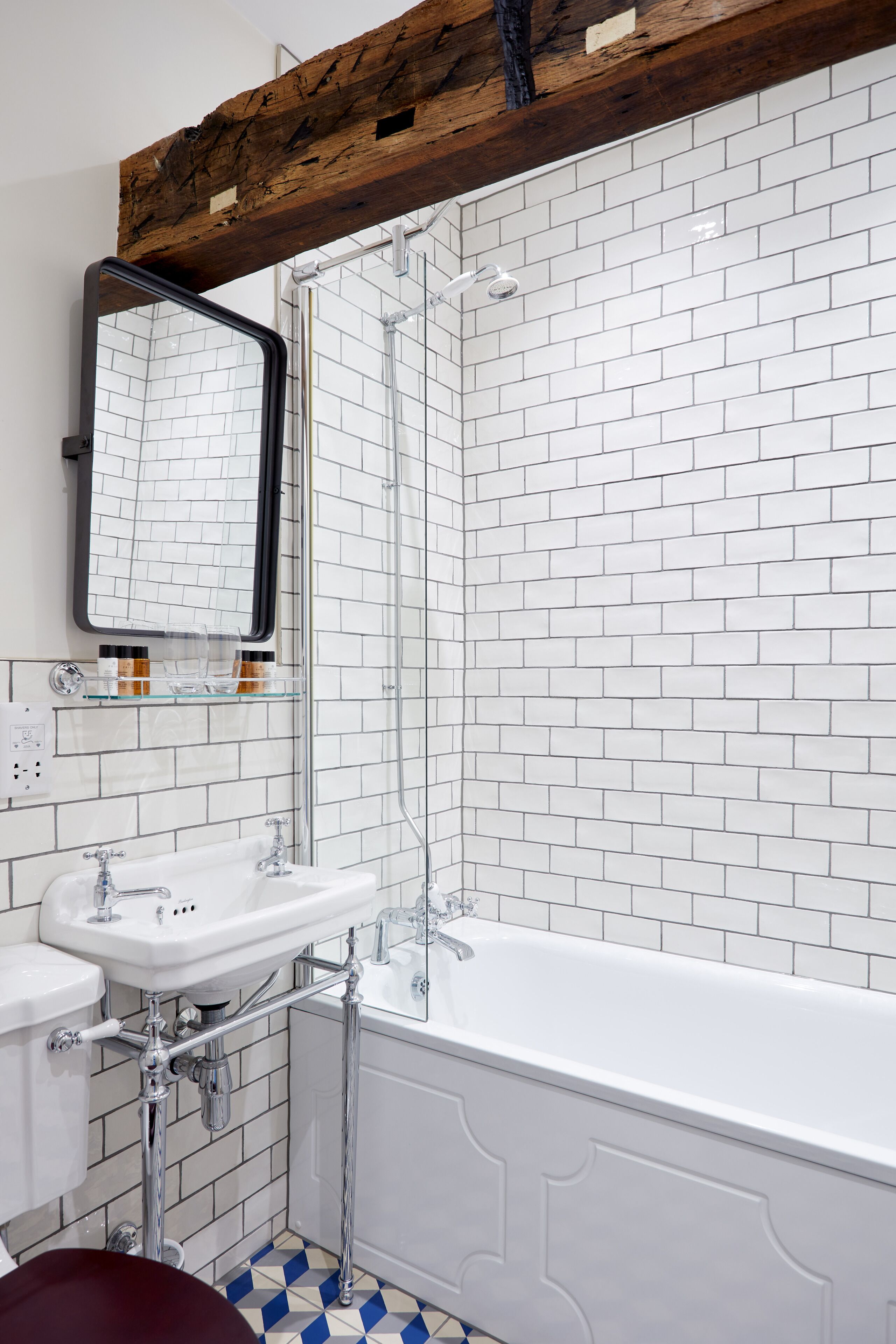 A bathroom with a white bathtub, a white sink, and a glass shower enclosure.