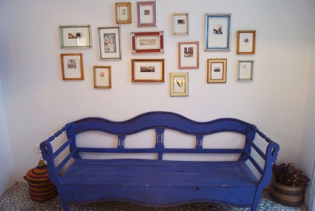Eine blaue Bank mit Fliesenboden und gerahmten Bildern an der Wand.