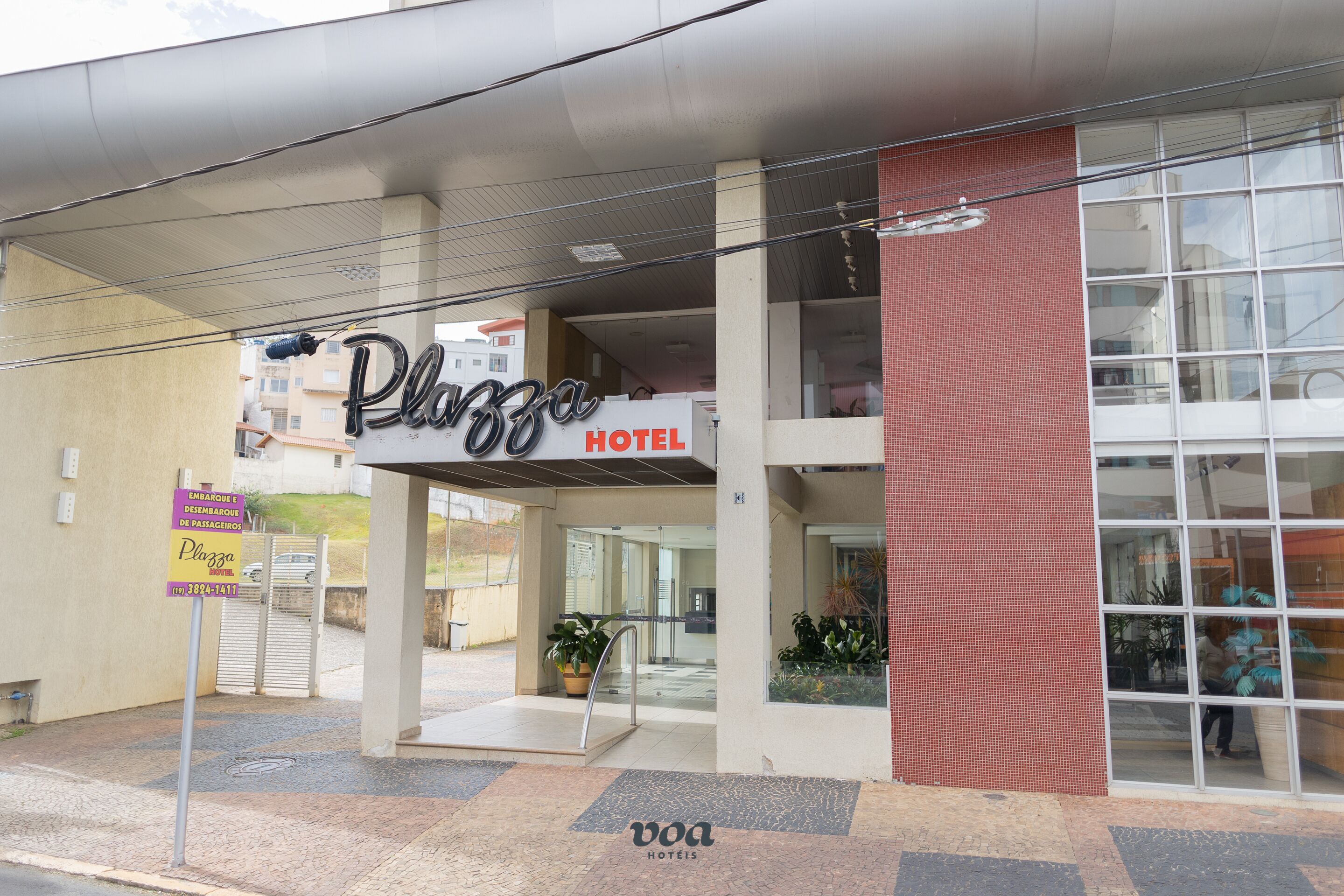 A hotel entrance with a sign reading "Plaza Hotel".