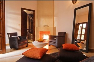 A modern living room with two sofas, a coffee table, and a fireplace.
