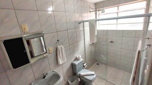 A modern bathroom with a sink, toilet, and shower area. - Pousada Águas de Lindóia (Águas de Lindóia)