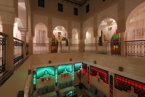 A spacious atrium with high ceilings, arched windows, and a central seating area with sofas and tables. - Riad Zaki (Marrakech)