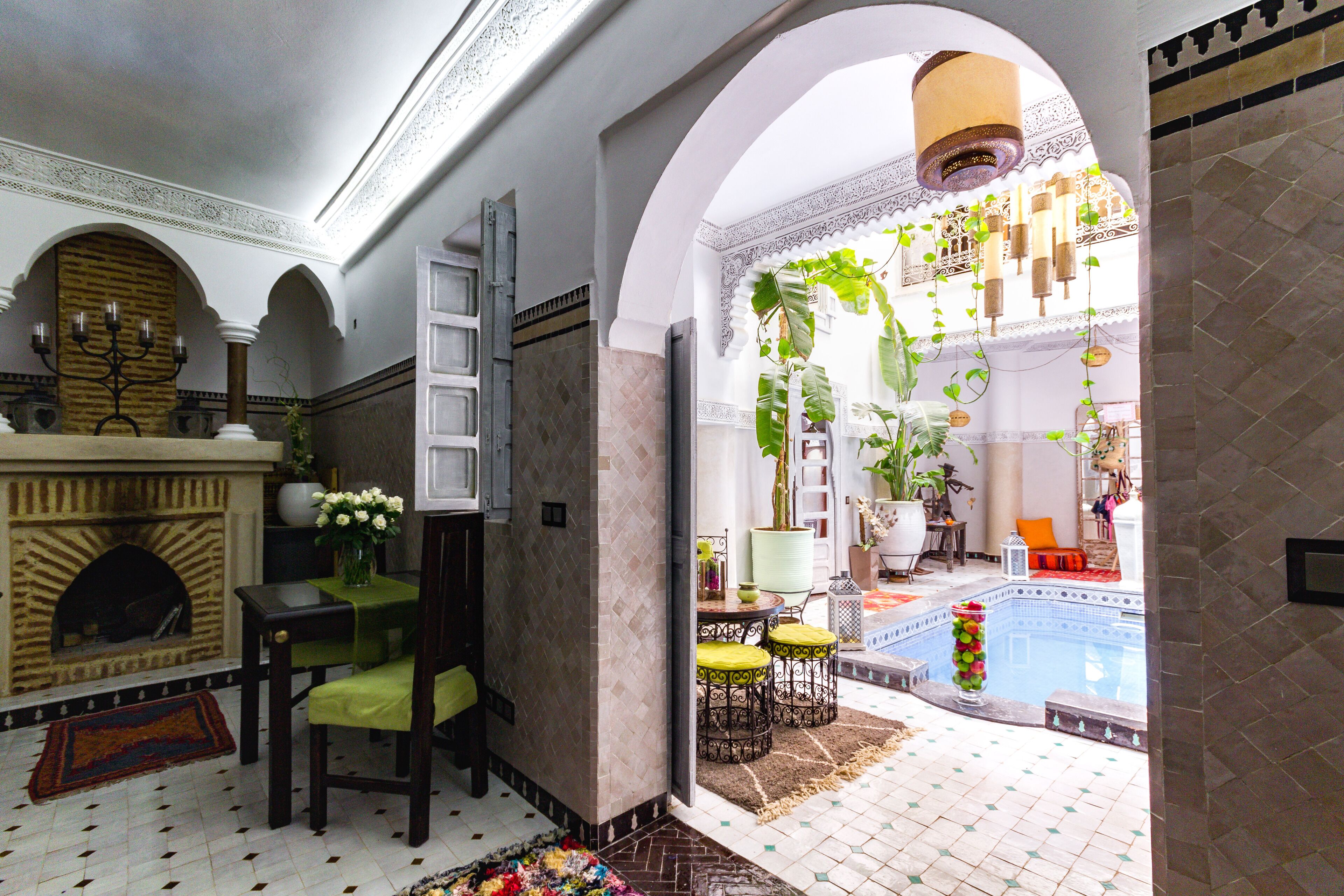 A traditional interior with a fireplace, seating area, and a view of an outdoor swimming pool.