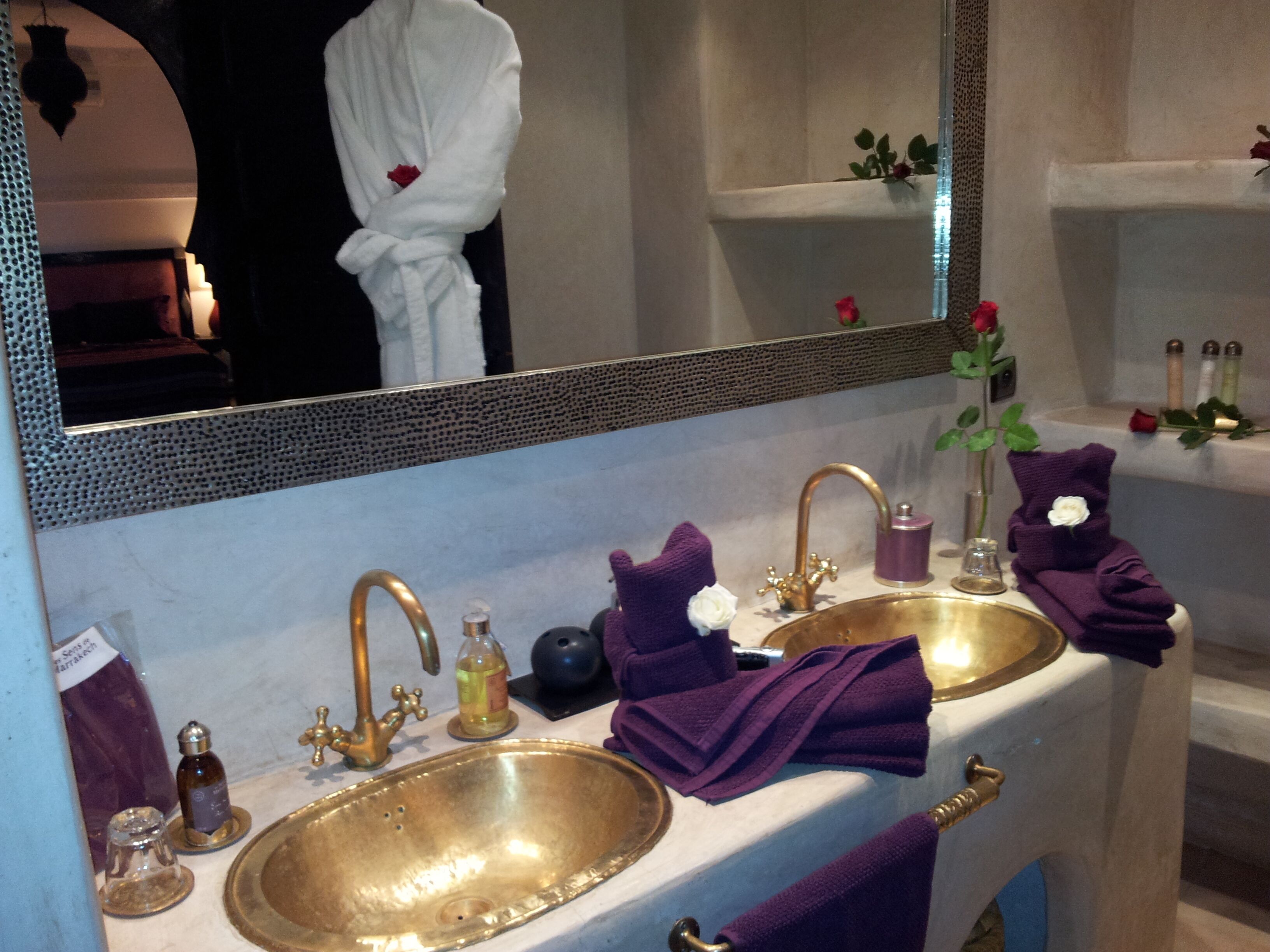 A bathroom with two sinks, a mirror, and toiletries.