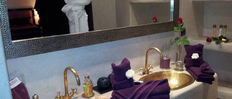 A bathroom with two sinks, a mirror, and toiletries.