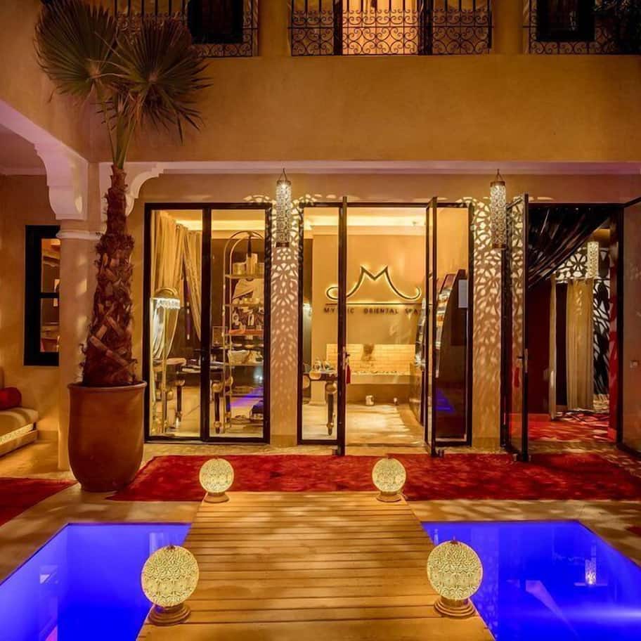 A hotel lobby with a red carpet, a reception desk, and a large mirror reflecting the interior.