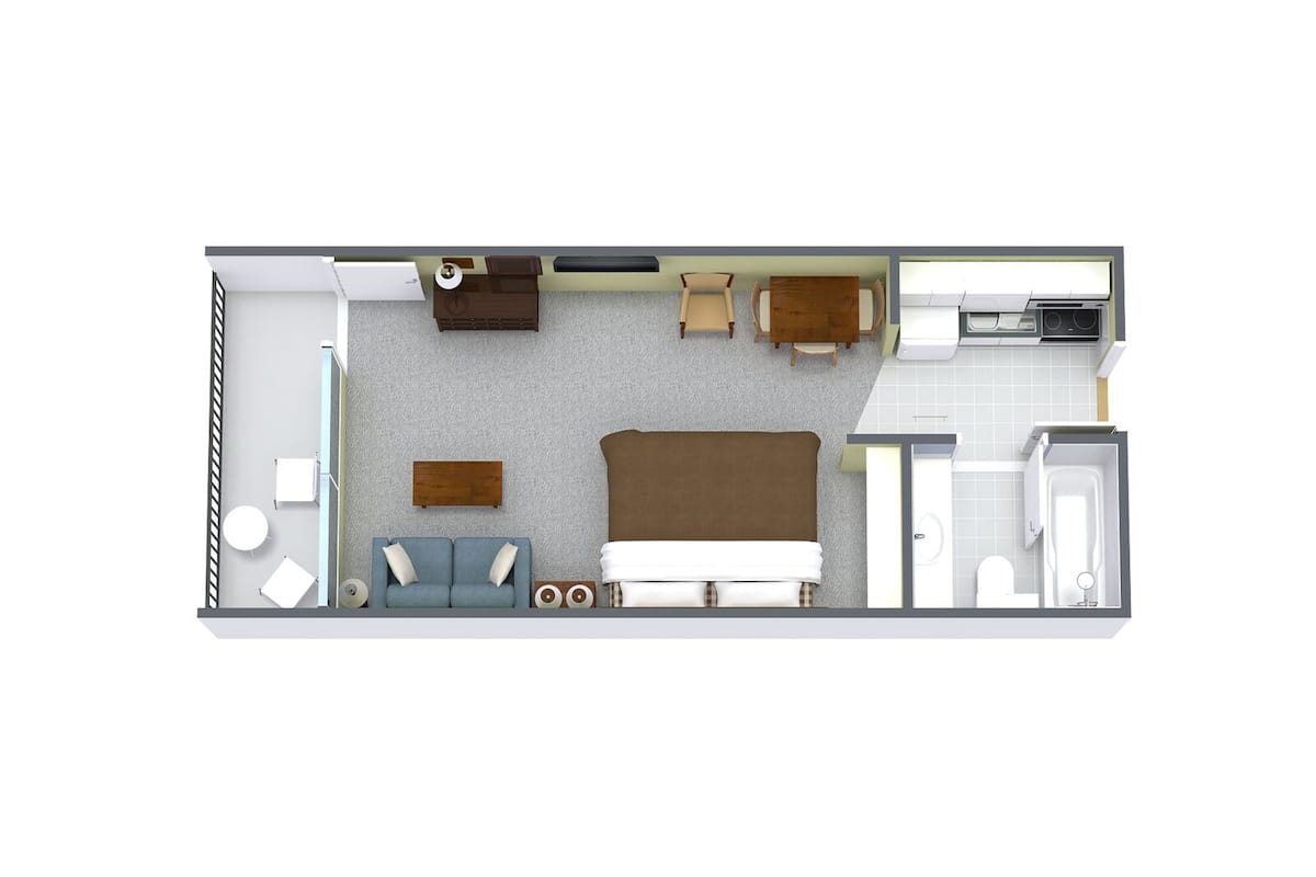 A hotel room layout with a bed, sofa, two chairs, a small table, a desk, and a bathroom.