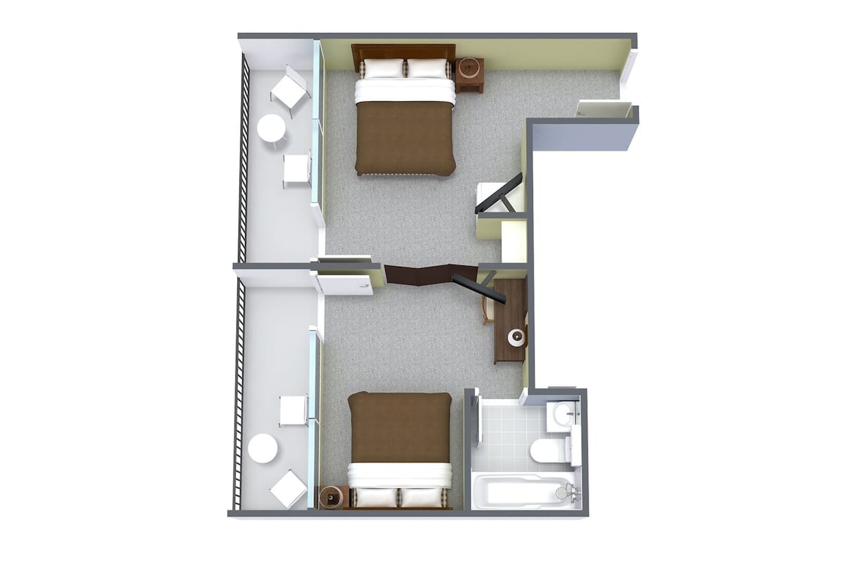 A hotel room layout with two beds, a bathroom, a small sitting area, and a desk.