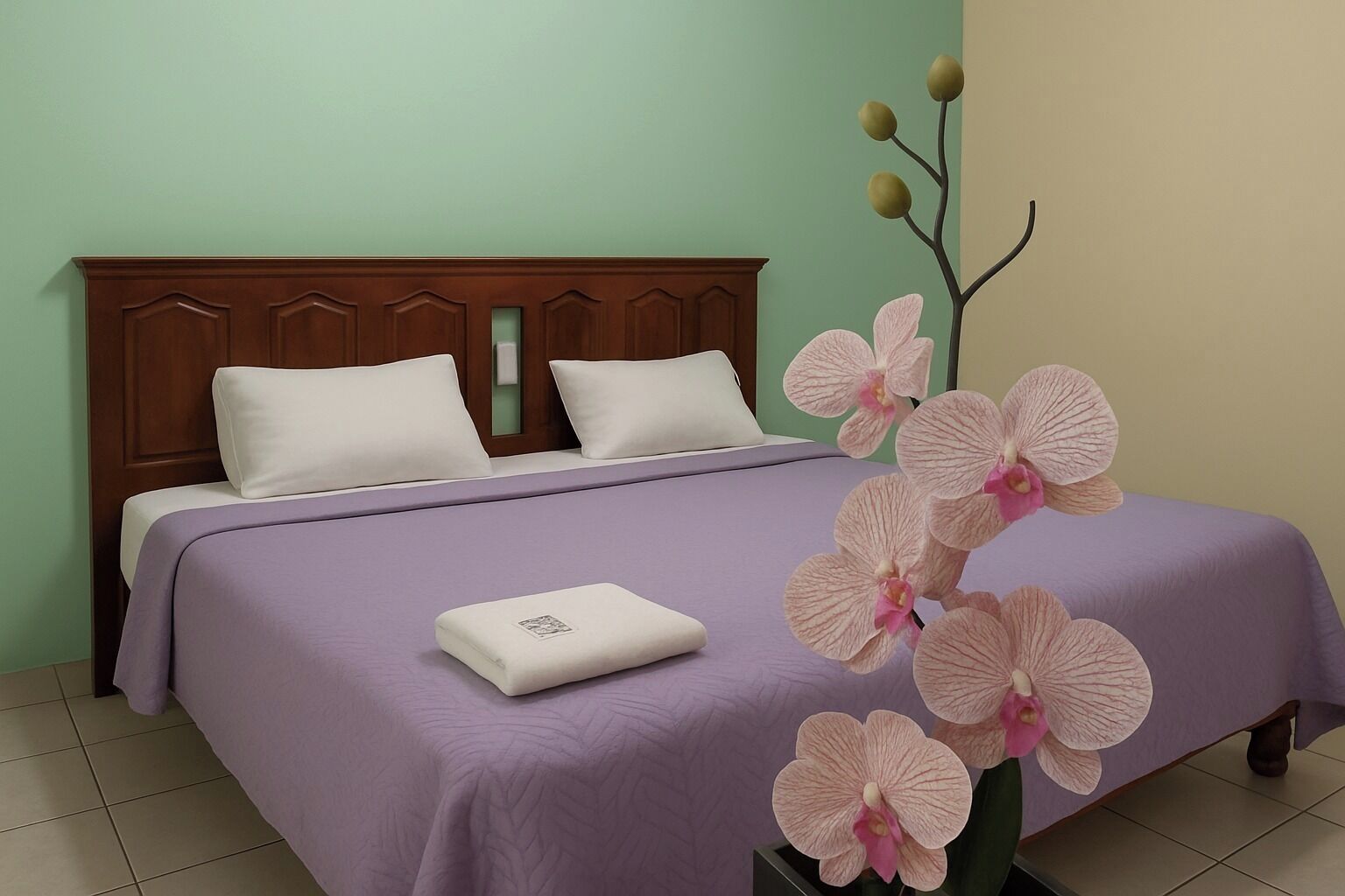 Una cama con una colcha morada, dos almohadas blancas y una funda de almohada blanca.
