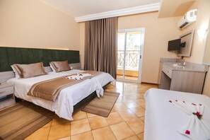 Habitación triple, vistas al jardín | Minibar, caja fuerte, tabla de planchar con plancha y camas supletorias