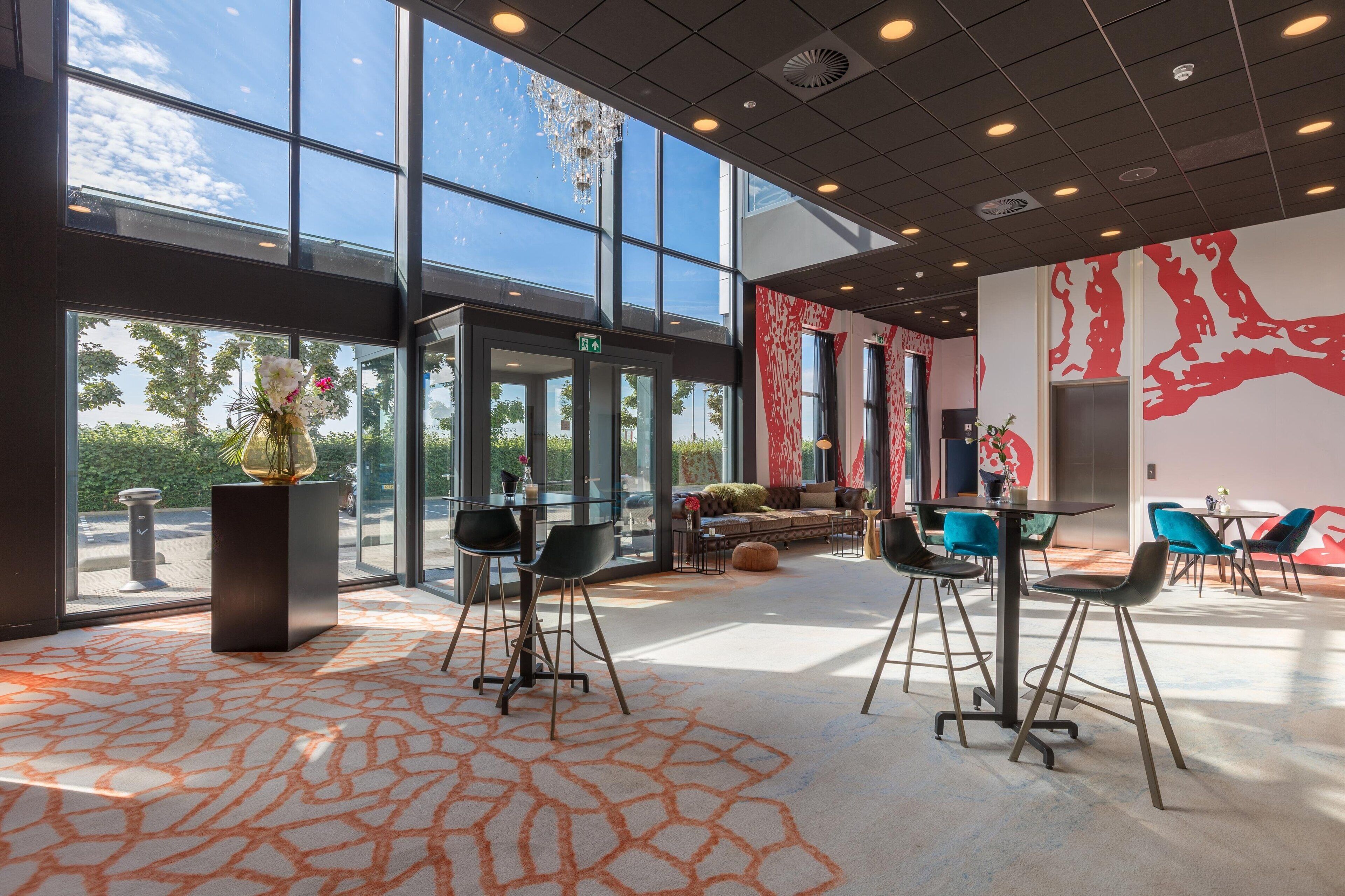 Un intérieur moderne avec de grandes fenêtres, un coin salon et un mur décoratif.