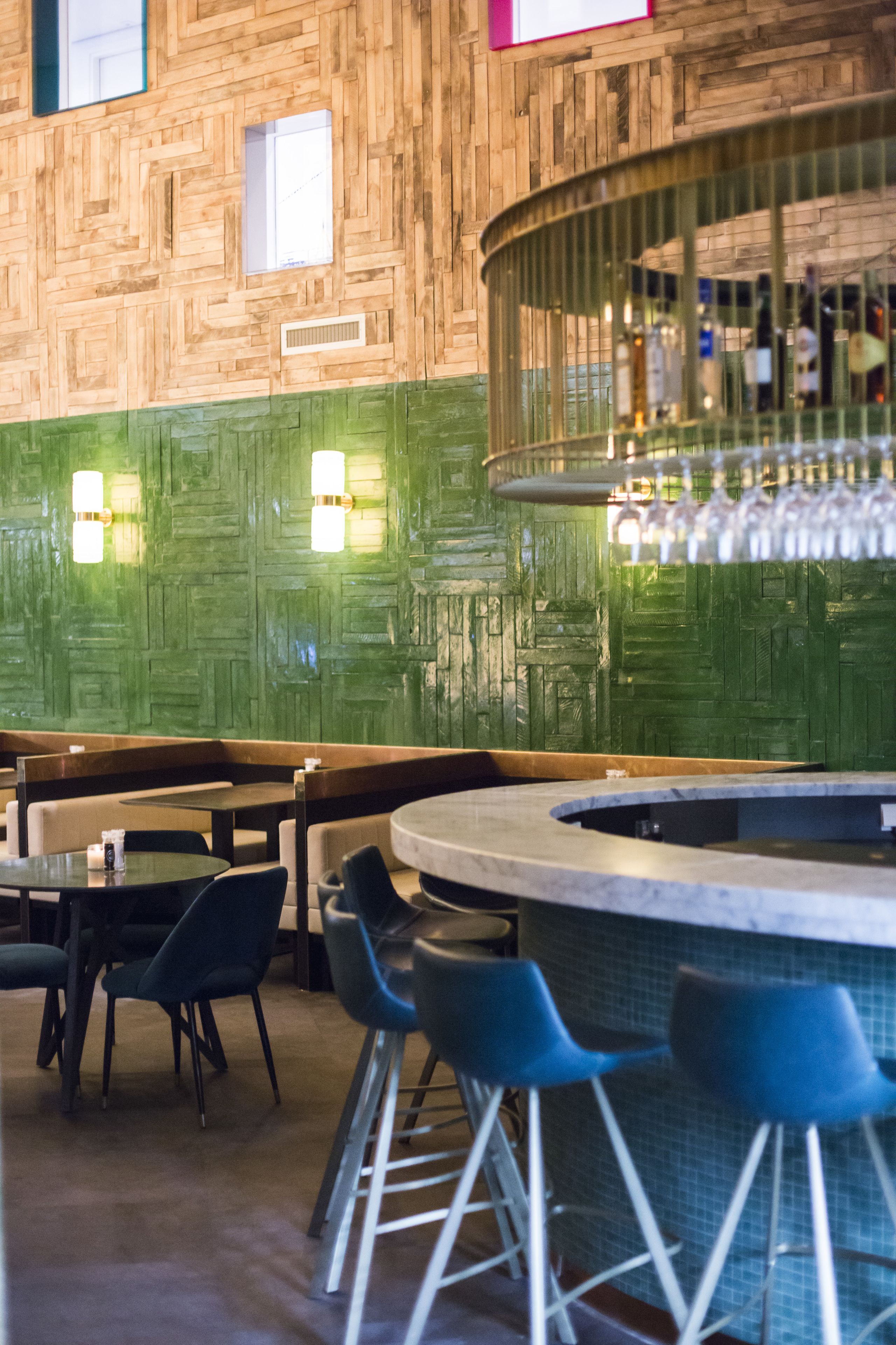 Interior de restaurante con paredes de madera, zona de bar y disposición de mesas.