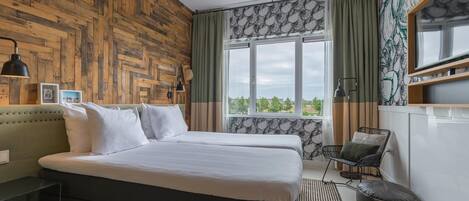 Un dormitorio con pared de madera, una cama grande, una ventana con cortinas, una silla y un escritorio.