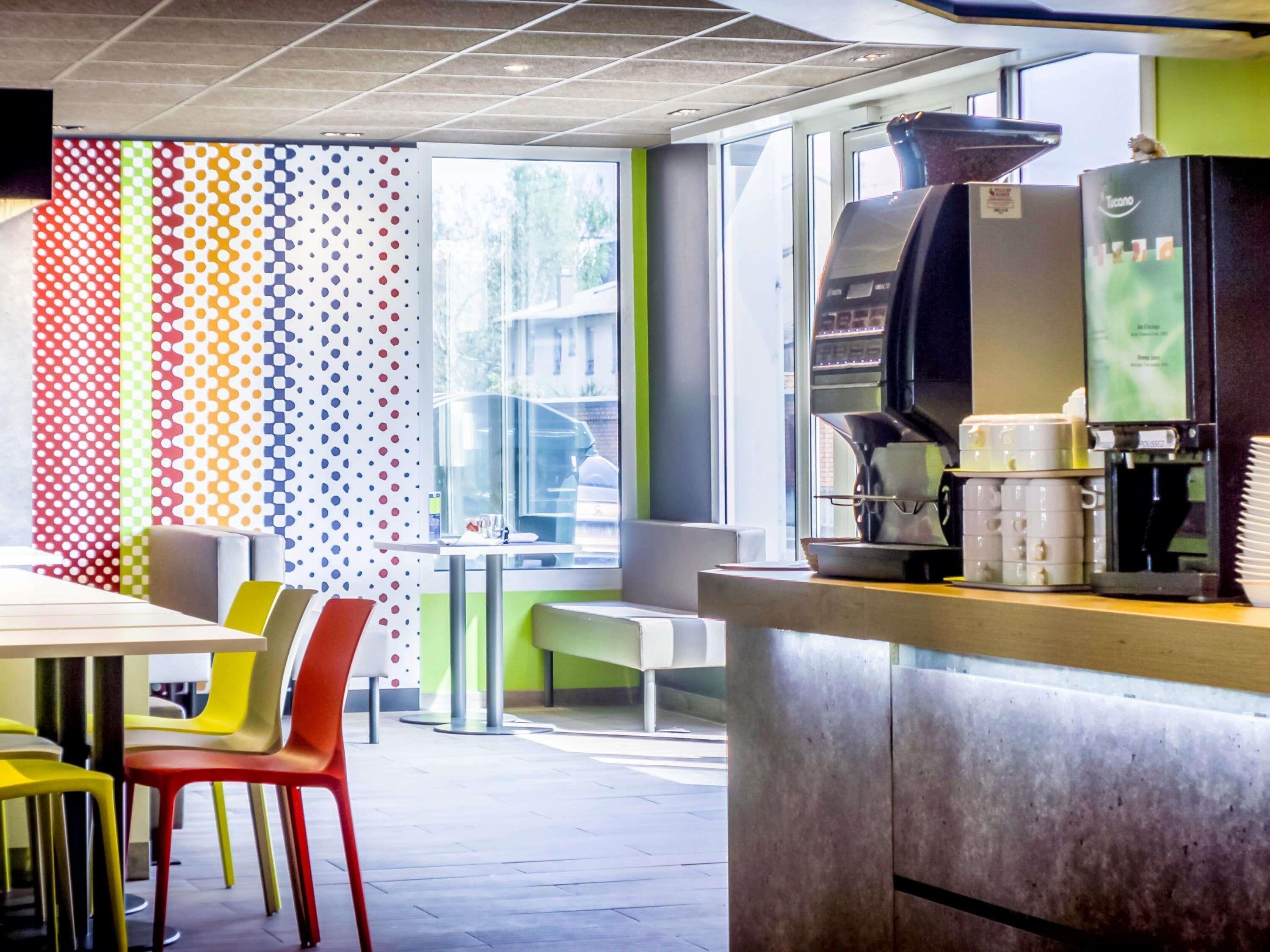 L’intérieur d’un café moderne, avec un comptoir, un espace salon et une machine à café.