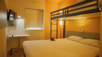 Een slaapkamer met een stapelbed, een klein bureau en een televisie.