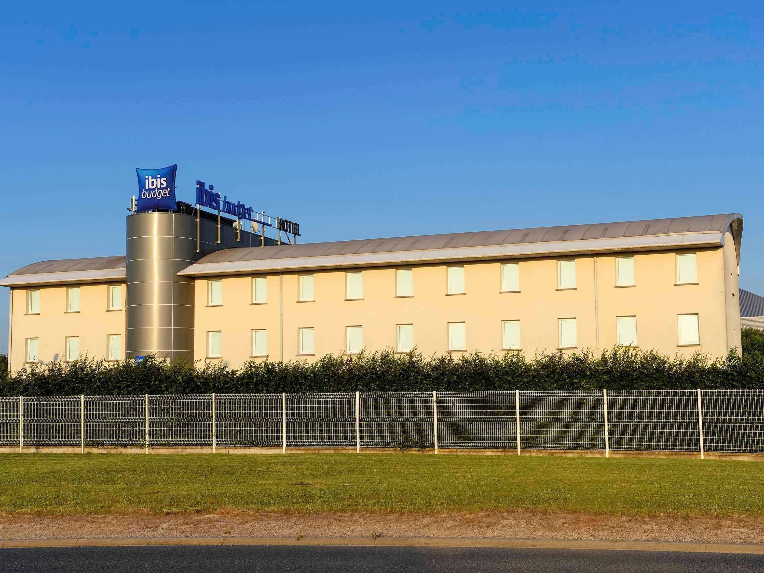 Un hotel dal design moderno, con una grande cisterna cilindrica ben visibile e una segnaletica che indica si tratta di un ibis budget.