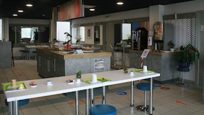 Un restaurante moderno con una barra larga, taburetes y una máquina de café.