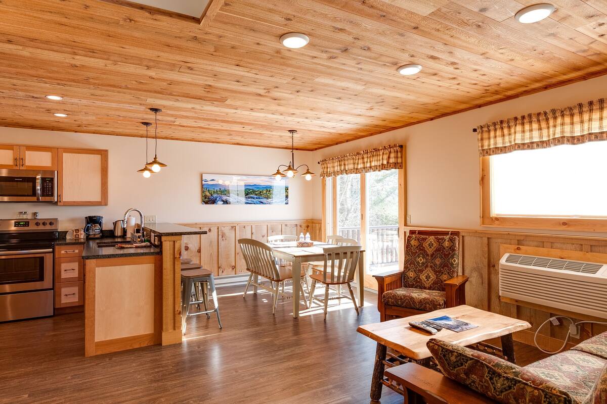 A wooden interior with a kitchen, dining area, and seating.