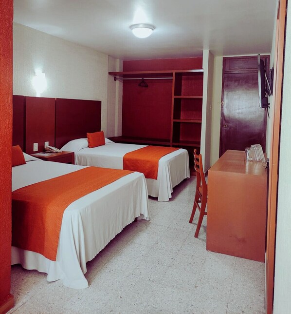 A hotel room with two beds, a desk, and a wardrobe. - Hotel Central Veracruz (Veracruz)