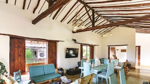 A rustic interior with a wooden ceiling, a dining area with blue chairs, and a sofa. - Hotel Boutique Venturi (Barichara)