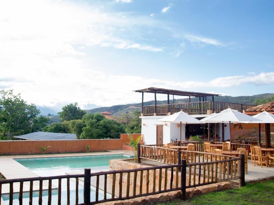 Zona de piscina con mobiliario exterior y vistas a las montañas.
