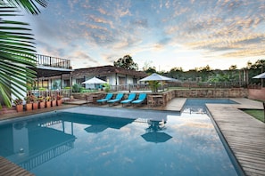 Una piscina al aire libre, tumbonas