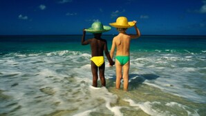 Two people standing in shallow water, wearing hats and swimwear. - Meida Hotel & Restaurant (Nuku'alofa)