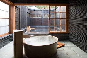 A traditional Japanese-style room with a wooden bathtub, a wooden cabinet, and a large window offering a view of the outside. - Miyama Sanso (Minamioguni)
